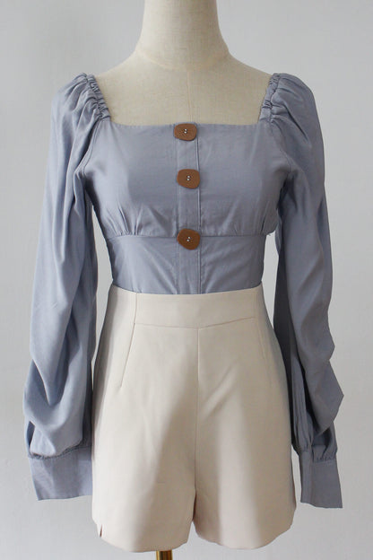 A square neck cropped top with long puffed sleeves. Complete with wooden finish buttons. 