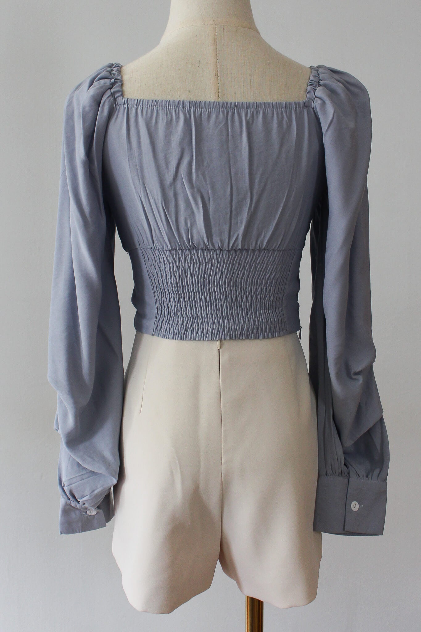 A square neck cropped top with long puffed sleeves. Complete with wooden finish buttons. 